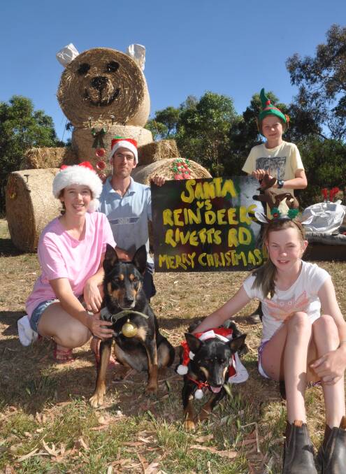 SEASONS GREETINGS: Samantha and Andrew Edwards and their cousin's Charlie and Tess Ingham, with kelpies Trixie and Liz, inspect their entry in the Avenue Range Christmas gate competition.