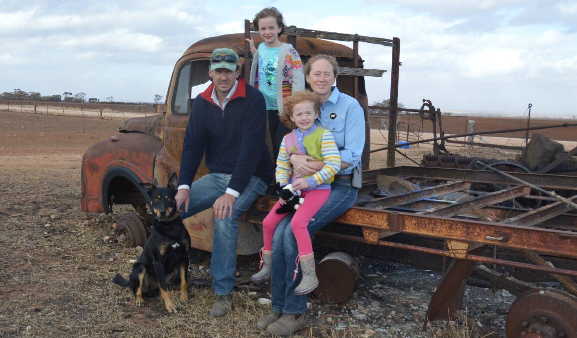 LOOKING AHEAD: Ashmore White Suffolk stud's Troy and Nette Fischer, Wasleys, and their daughters Isabelle, 7, and Indigo, 5, on a burnt-out shell of a truck on their farm.